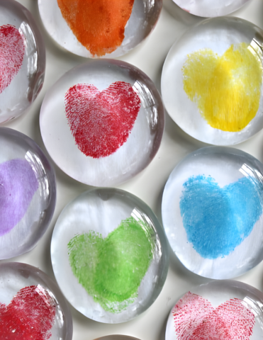 Photo of round glass magnets decorated with thumbprints in the shape of hearts